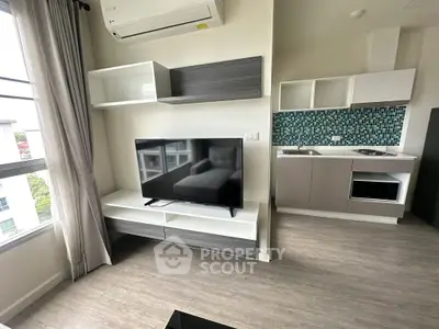 Modern living room with sleek TV unit and stylish kitchen area