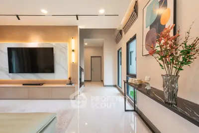 Modern living room with sleek design, large TV, and elegant decor in a spacious open layout.