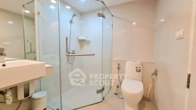 Modern bathroom with glass shower enclosure and sleek fixtures