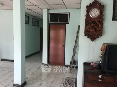 Charming interior with vintage clock and wooden door, offering a cozy atmosphere.