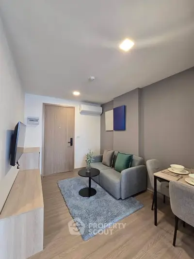 Modern living room with cozy sofa, stylish decor, and dining area in a contemporary apartment.