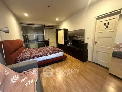 Spacious bedroom with modern decor and wooden flooring in a stylish apartment.