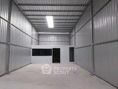 Spacious industrial warehouse with high ceilings and metal walls, ideal for storage or manufacturing.