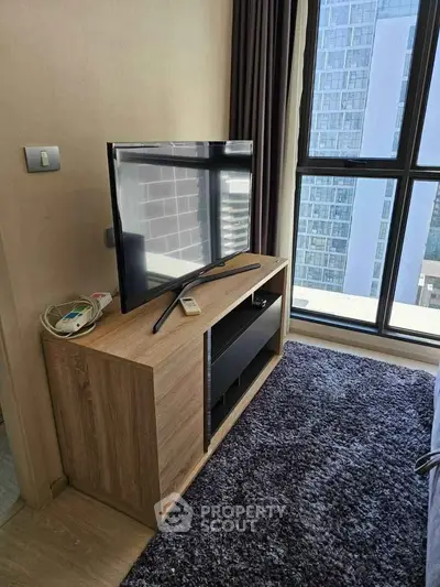 Modern living room with TV stand and large window offering city view