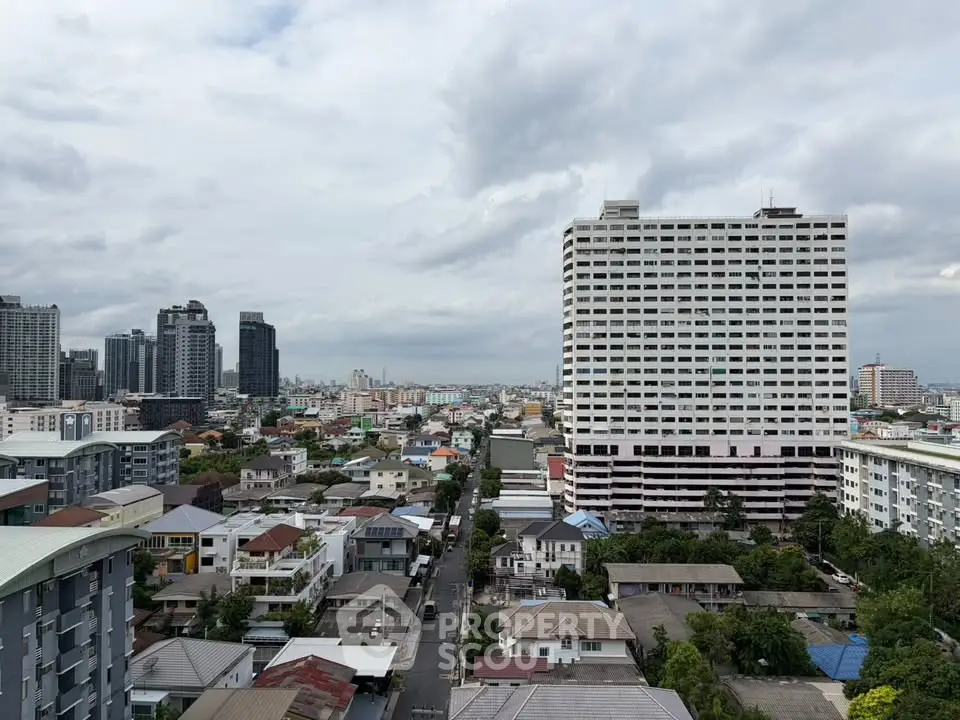Stunning cityscape view showcasing high-rise buildings and residential area under a cloudy sky.