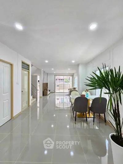 Spacious modern living area with sleek tile flooring and elegant dining setup.