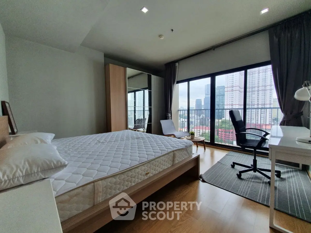 Spacious bedroom with city view, modern furnishings, and ample natural light.
