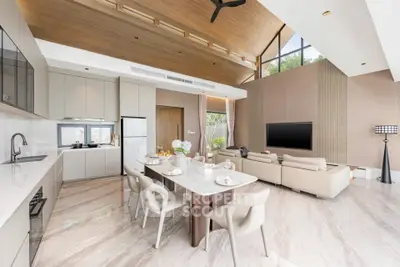 Luxurious open-plan living room with modern kitchen and elegant dining area, featuring high ceilings and natural light.