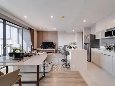 Modern open-plan living room and kitchen with sleek design and natural light.