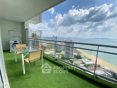 Stunning high-rise balcony with ocean view and outdoor dining area on artificial grass.