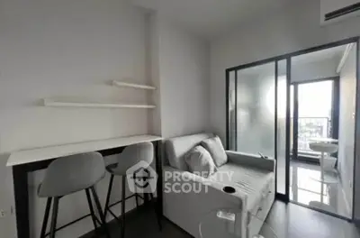Modern living room with sleek furniture and balcony access in a contemporary apartment.