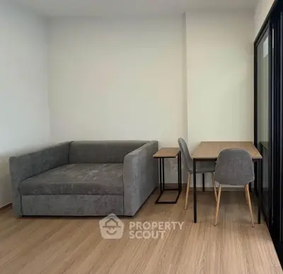 Modern living room with sleek gray sofa and stylish wooden table set on elegant wooden flooring.