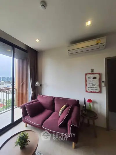 Cozy living room with maroon sofa and balcony view in modern apartment