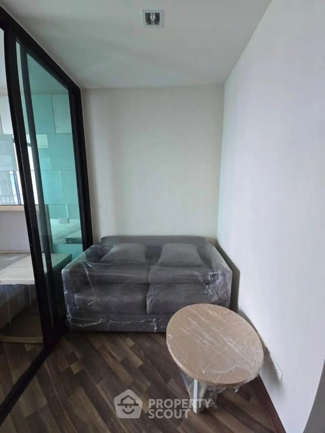 Compact living space with modern furniture and glass partition, ideal for urban living.