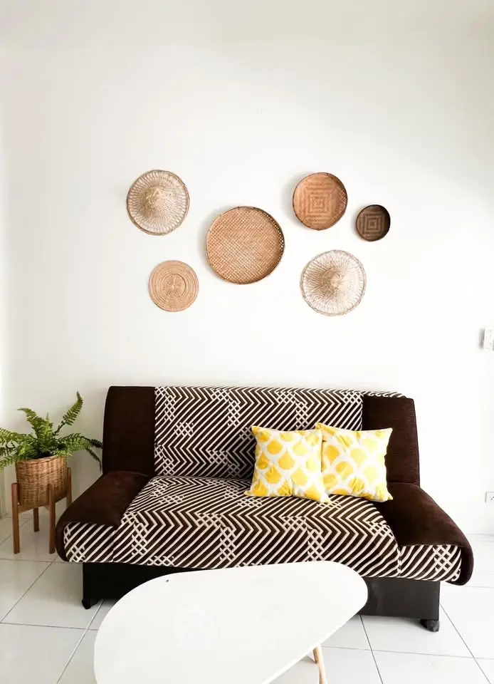 Stylish living room with patterned sofa, decorative wall baskets, and vibrant yellow cushions.
