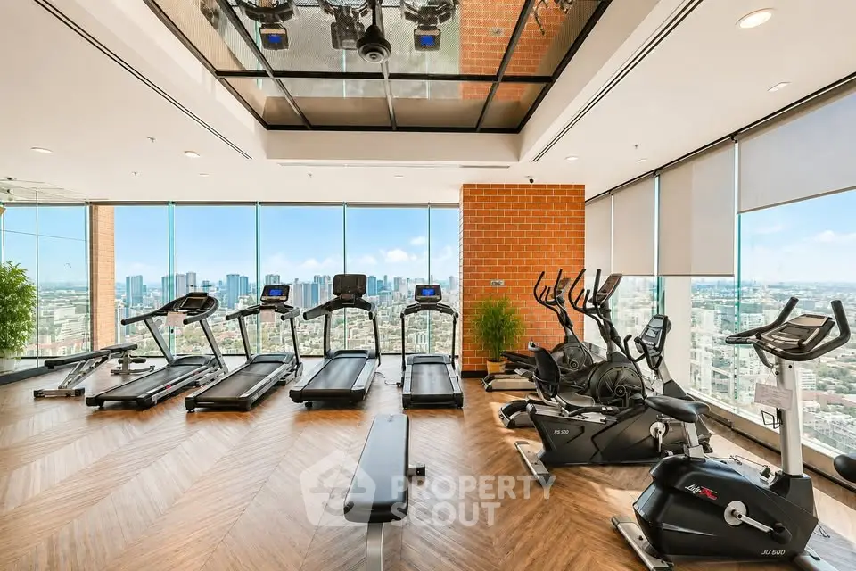 Luxurious high-rise gym with panoramic city views and modern fitness equipment.