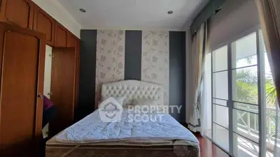 Spacious bedroom with elegant decor and large windows offering natural light
