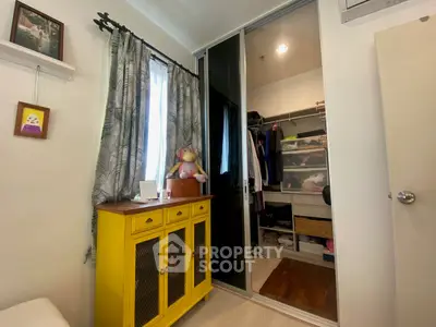 Charming bedroom with mirrored closet and vibrant yellow cabinet, perfect for cozy living.