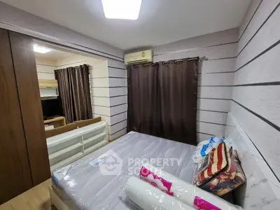 Cozy bedroom with modern decor and air conditioning, featuring a comfortable bed and stylish curtains.