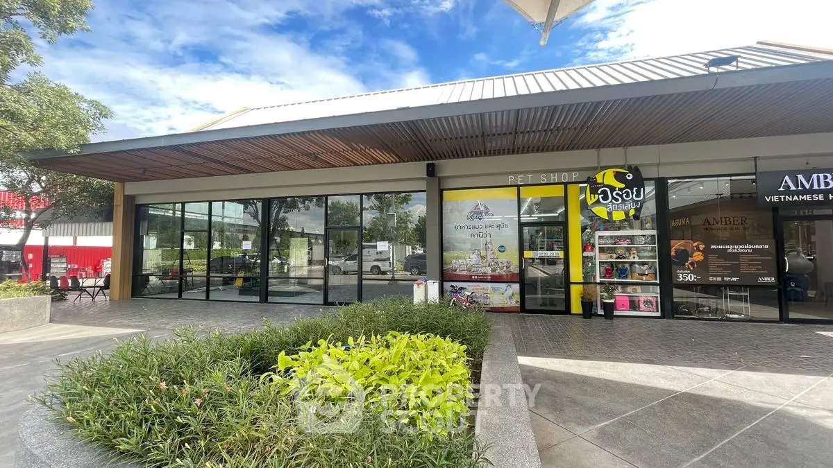 Modern commercial building with glass facade and lush landscaping