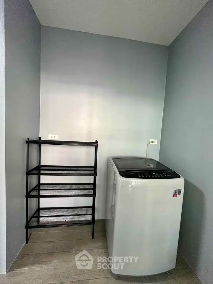 Modern laundry area with washing machine and shelving in sleek minimalist design.