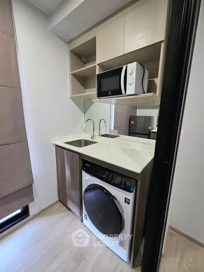 Compact modern kitchen with built-in microwave and washing machine
