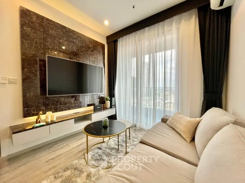 Luxurious living room with modern decor, large TV, and elegant curtains in a stylish apartment.