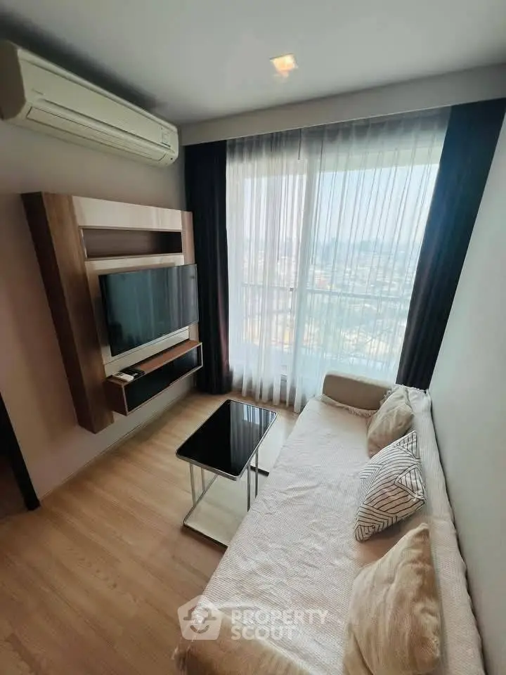 Modern living room with large window and stylish furniture in high-rise apartment.