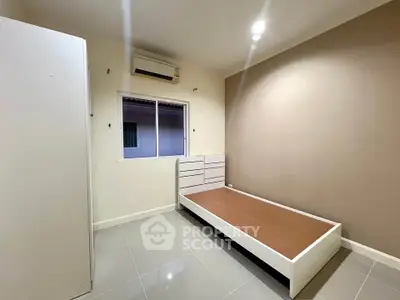 Minimalist bedroom with sleek flooring and modern air conditioning unit.