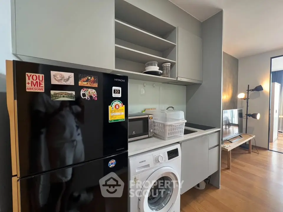 Modern kitchen with washing machine and fridge in stylish apartment
