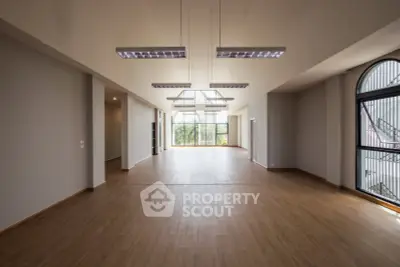 Spacious modern living room with large windows and elegant wooden flooring