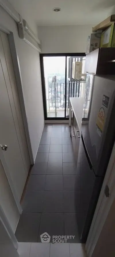 Compact kitchen with balcony view in modern apartment