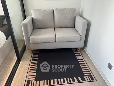 Modern compact living room with stylish gray sofa and patterned rug