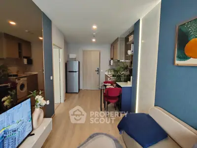 Modern living room with open kitchen, stylish decor, and cozy seating area.