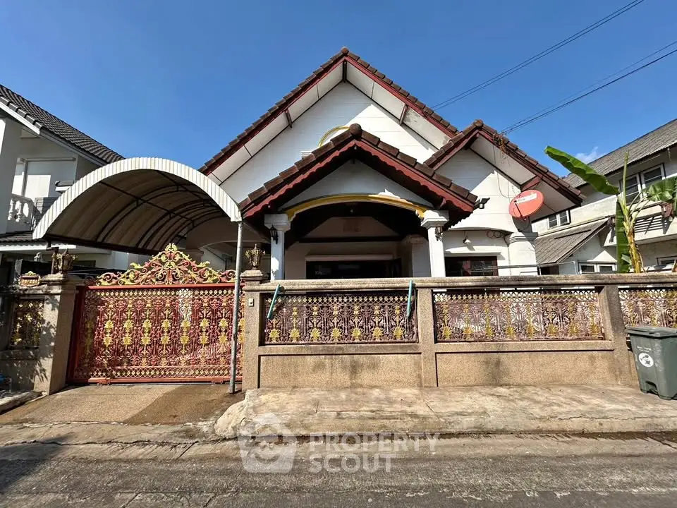 Charming suburban house with ornate gate and traditional architecture.