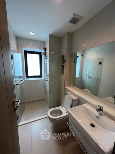 Modern bathroom with glass shower and sleek fixtures in a contemporary apartment.