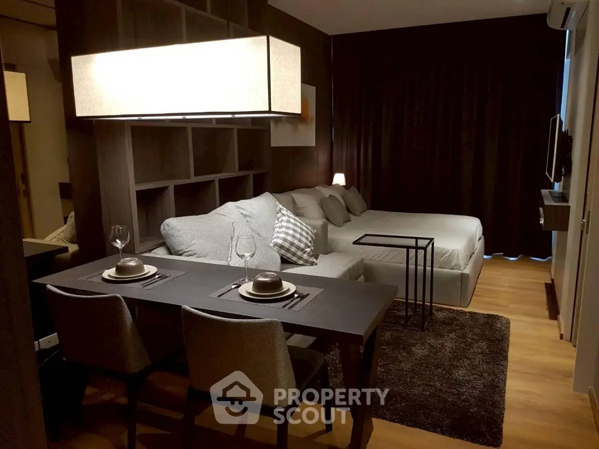 Modern studio apartment with cozy living area and dining space, featuring elegant decor and ambient lighting.