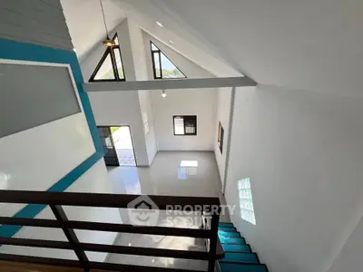 Spacious modern interior with high ceilings and large windows offering natural light.