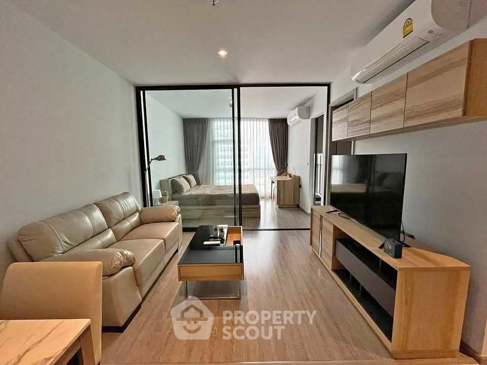 Modern living room with glass partition and cozy bedroom view