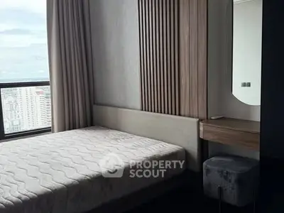 Modern bedroom with large window offering city view and stylish decor.