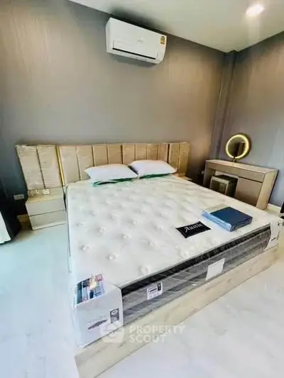 Luxurious bedroom with modern decor and air conditioning, featuring a plush bed and stylish furniture.