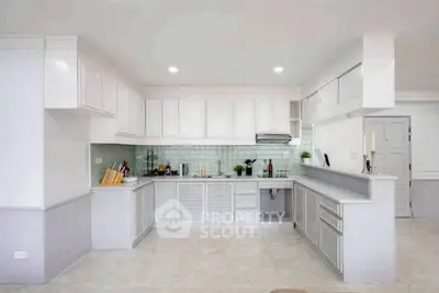 Spacious modern kitchen with sleek white cabinetry and open layout design.