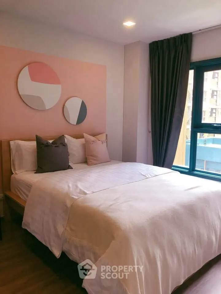 Cozy bedroom with modern decor and large window for natural light.