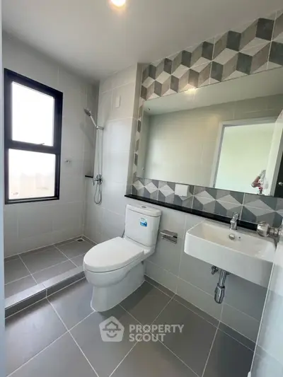 Modern bathroom with geometric tile design and sleek fixtures