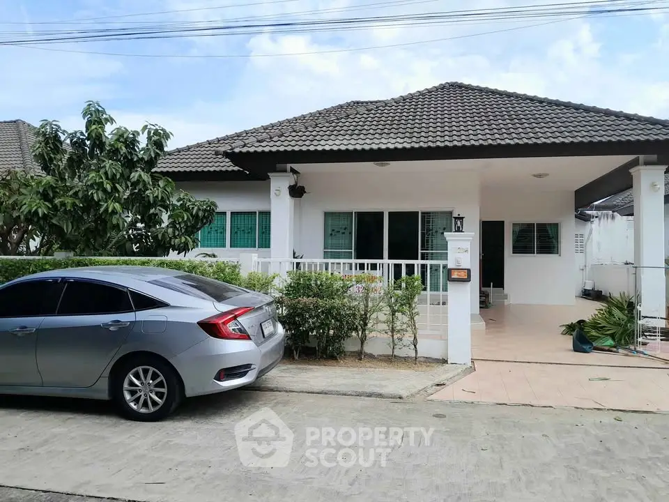 Charming single-story house with a tiled roof and spacious driveway, perfect for modern family living.