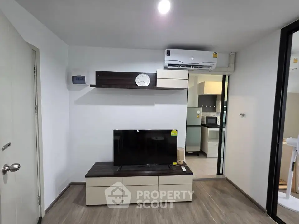 Modern living room with sleek TV unit and air conditioning in stylish apartment.