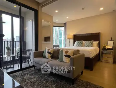 Modern bedroom with cozy seating area and balcony view in urban apartment