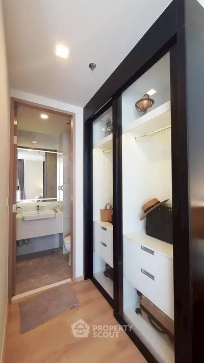 Modern walk-in closet with sleek sliding doors and bathroom view