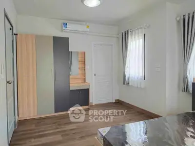 Spacious bedroom with modern wardrobe and air conditioning in a bright apartment.
