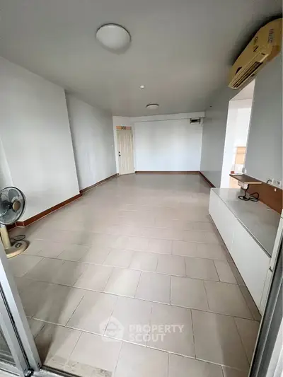 Spacious unfurnished living room with tiled flooring and air conditioning unit.